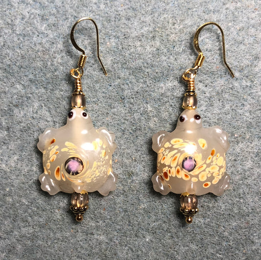 Large spotted beige lamp work turtle bead earrings adorned with beige Czech glass beads.