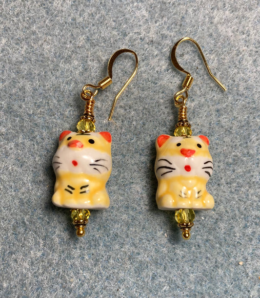 Yellow, black, and red ceramic tiger bead earrings adorned with yellow Chinese crystal beads.