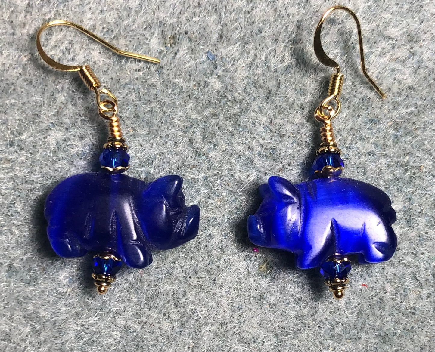 Dark blue fiber optic (cat’s eye) pig bead earrings adorned with dark blue Chinese crystal beads.