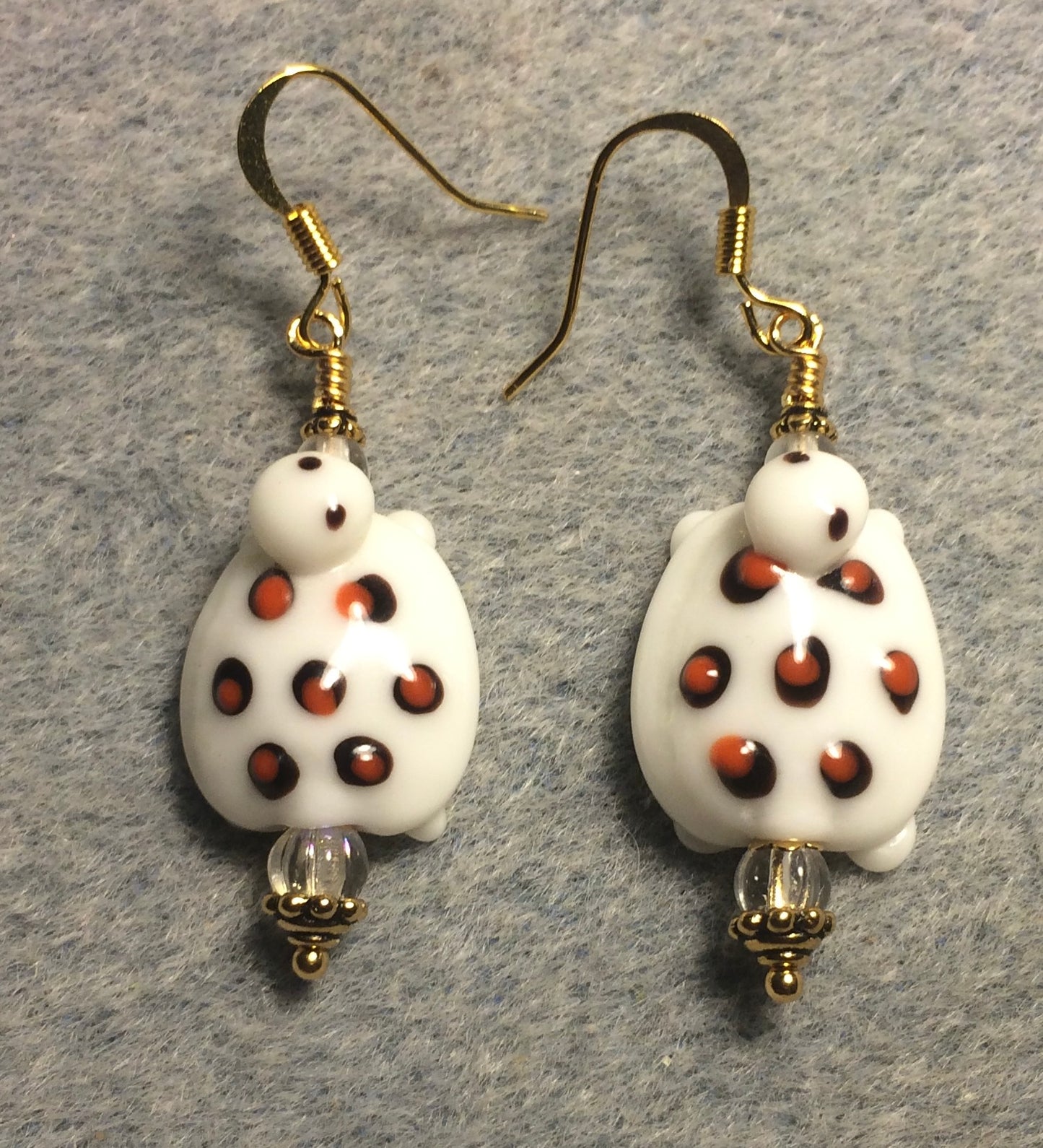 White with orange spots lamp work turtle bead earrings adorned with clear Czech glass beads.