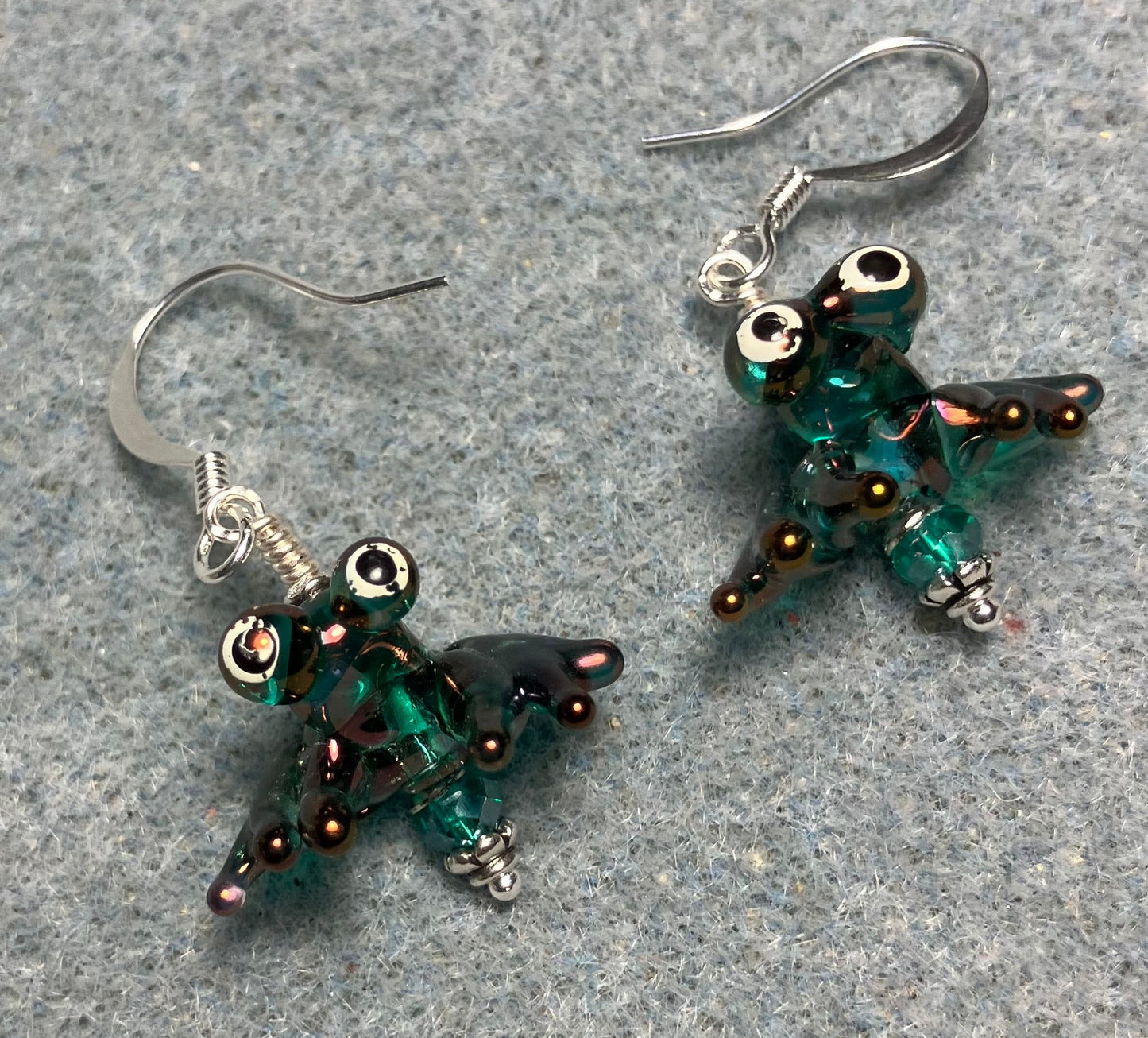 Tiny aurora borealis teal lamp work frog bead earrings adorned with tiny teal Chinese crystal beads.