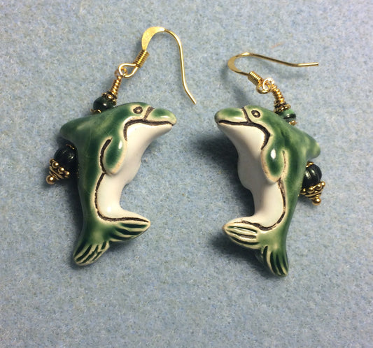 Green and white ceramic dolphin bead earrings adorned with green Czech glass beads.
