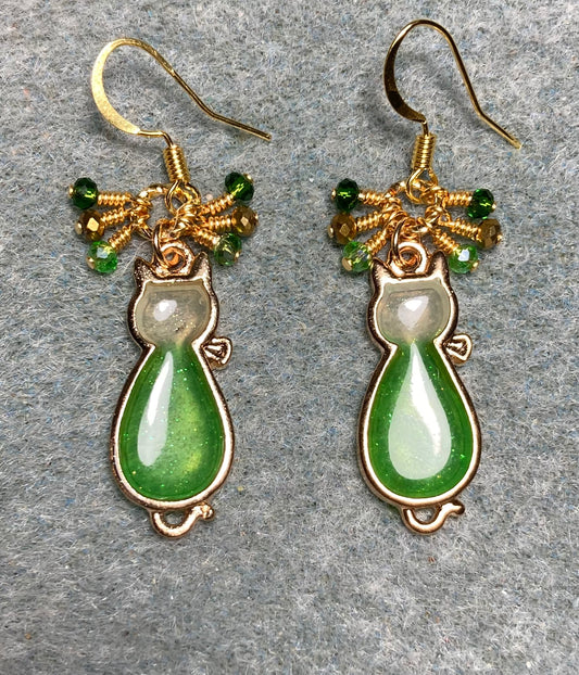 Green and gold sparkly resin cat charm earrings adorned with small dangling green and gold Chinese crystal beads.
