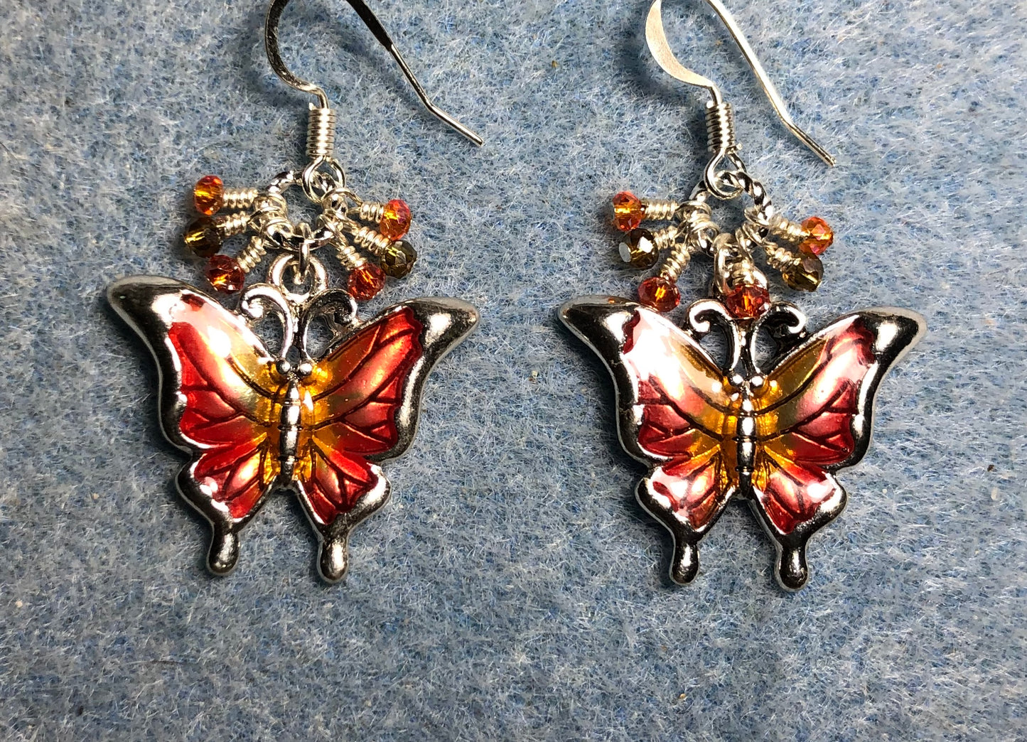 Red, orange, and amber enamel butterfly charm earrings adorned with tiny dangling red, orange, and amber Chinese crystal beads.