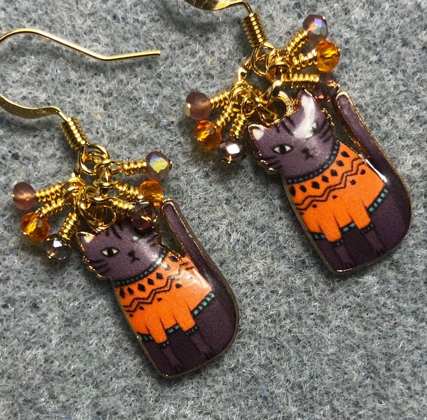 Lavender and orange enamel cat charm earrings adorned with tiny dangling lavender and orange Chinese crystal beads.