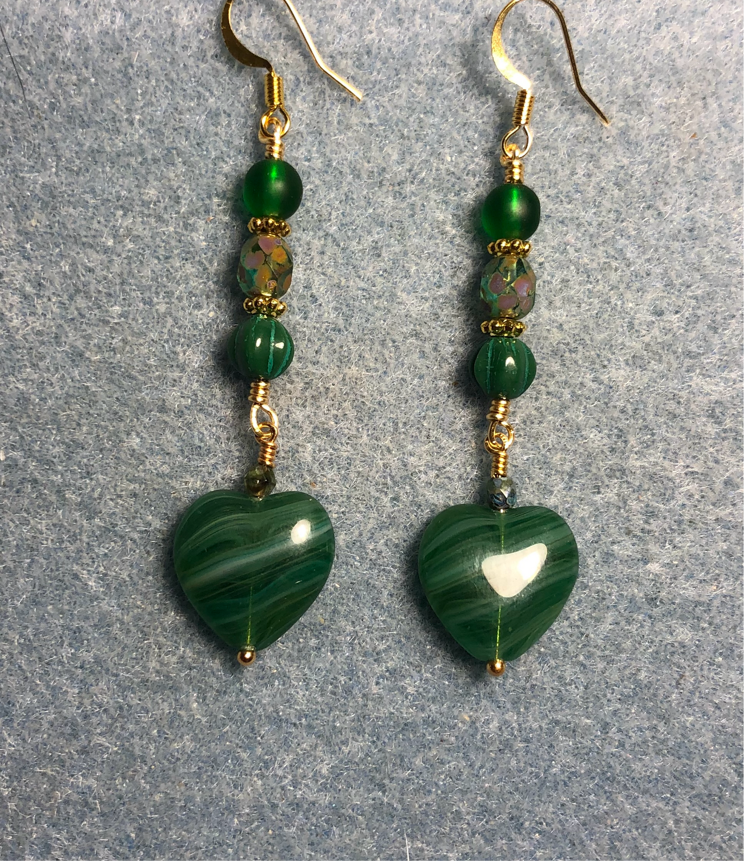 Opaque striped emerald green Czech glass heart bead earrings adorned with emerald green Czech glass beads.