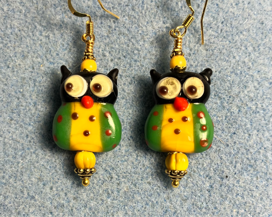 Green and golden yellow lamp work owl bead earrings adorned with golden yellow Czech glass beads.