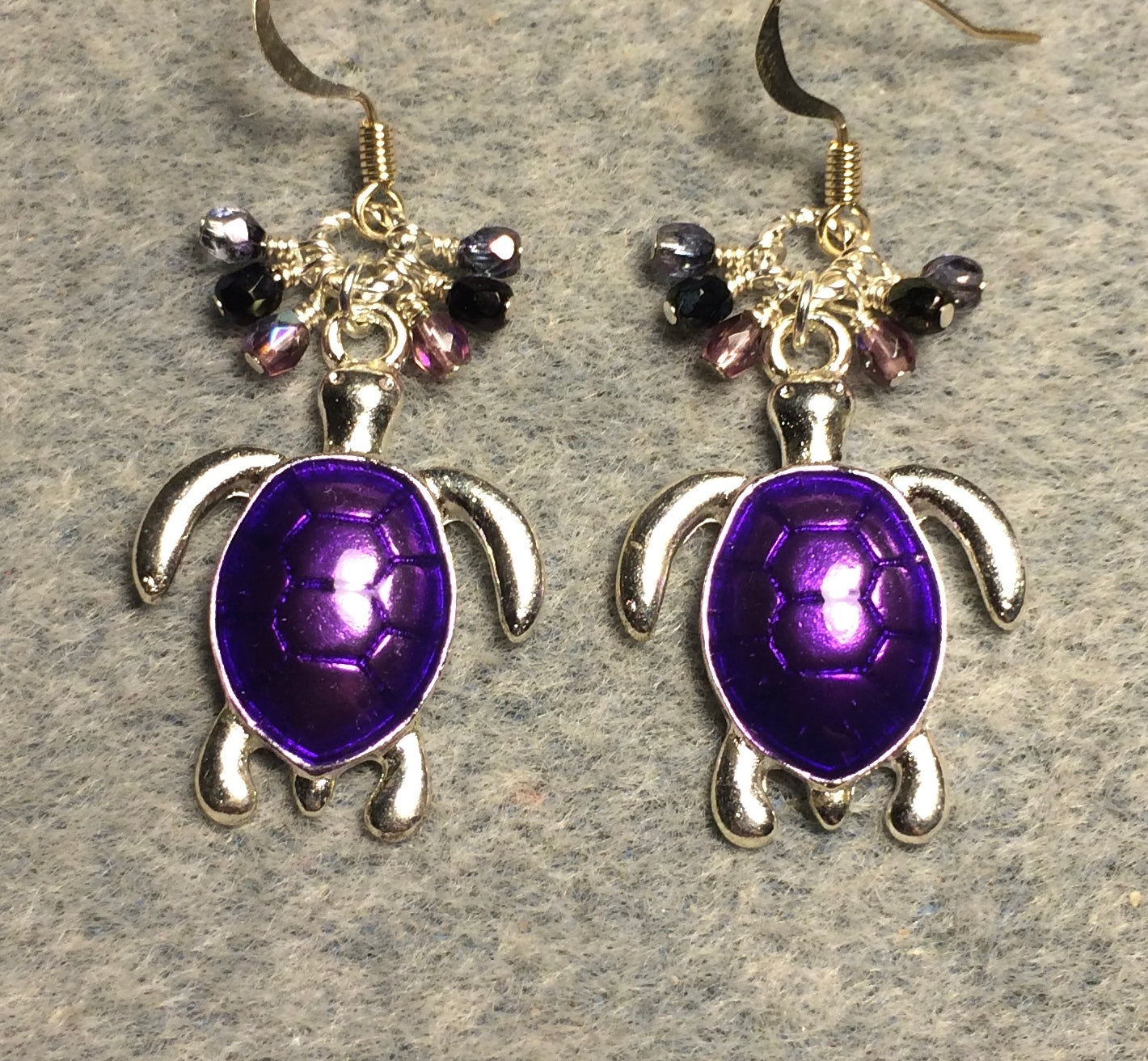 Silver and bright purple enamel sea turtle charm earrings adorned with small dangling purple and lavender Czech glass beads.