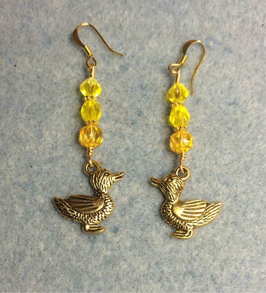 Gold duck charm earrings adorned with yellow Czech glass beads.