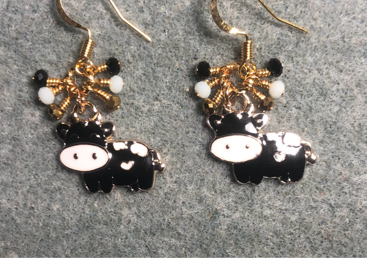 Black and white enamel cow charm earrings adorned with tiny dangling black, white, and gold Chinese crystal beads.
