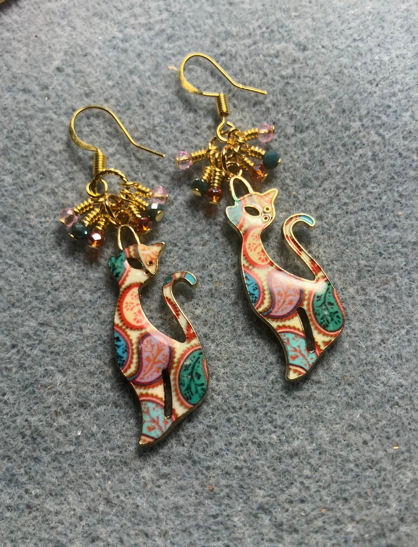Pink, teal, and orange enamel paisley patterned cat charm earrings adorned with tiny dangling pink, teal, and orange Chinese crystal beads.