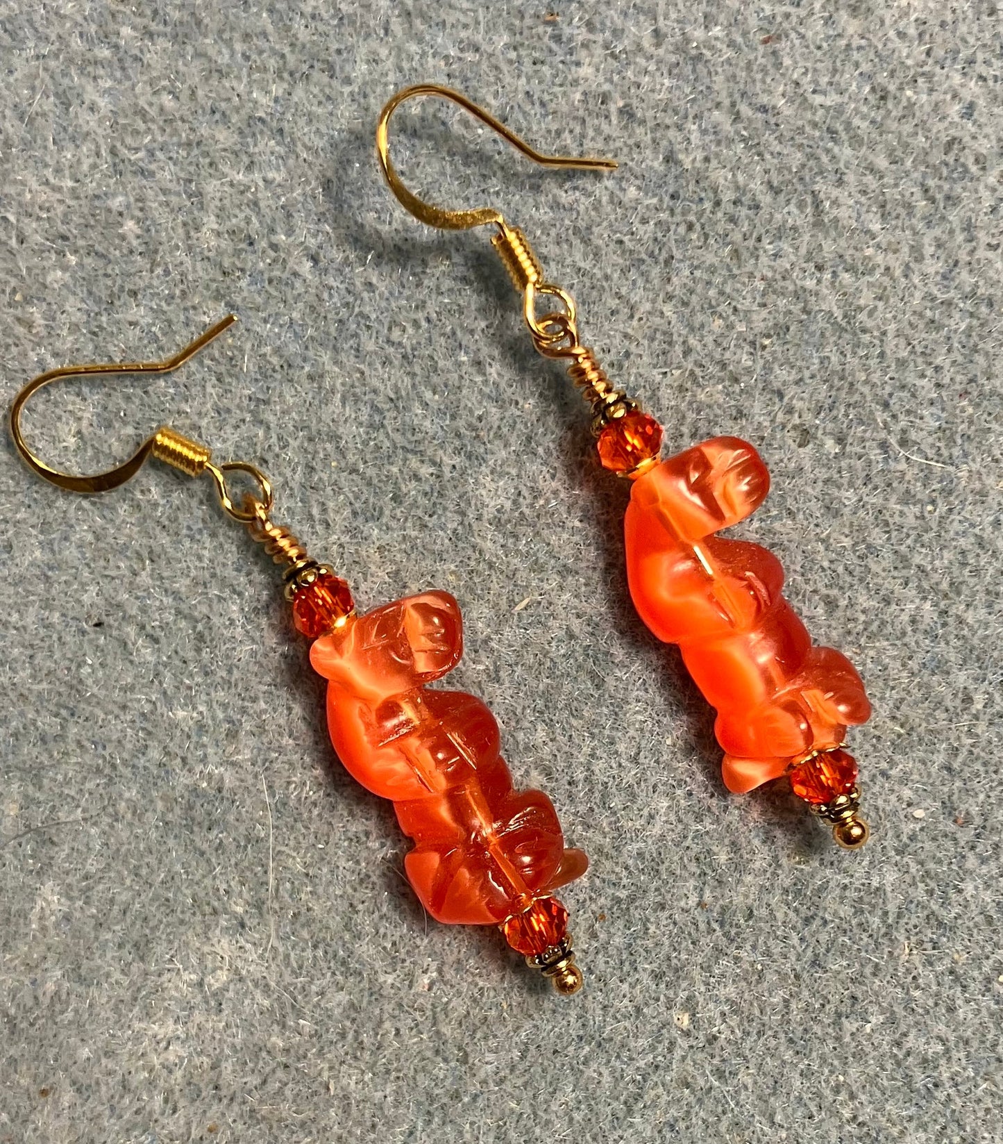 Orange fiber optic (cat’s eye) standing otter bead earrings adorned with orange Chinese crystal beads