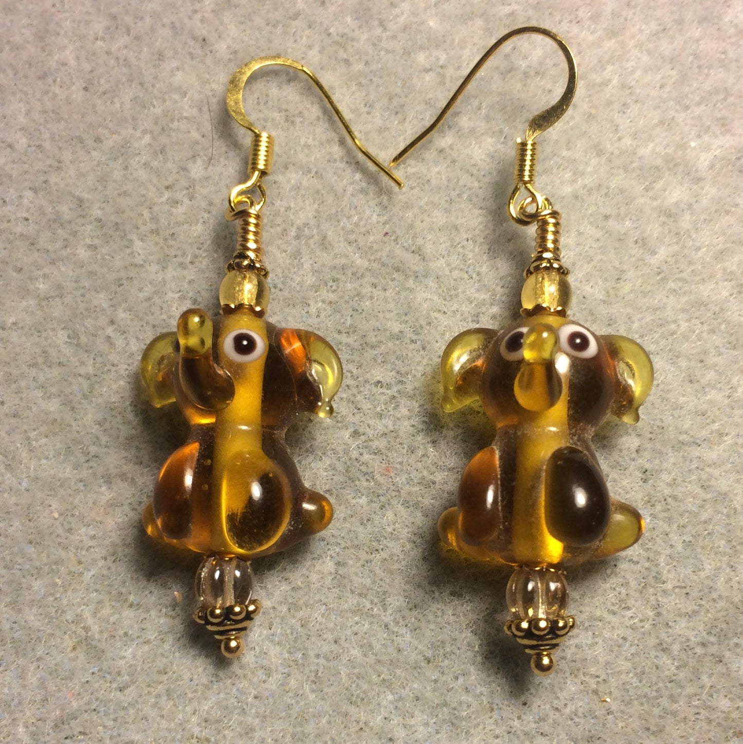 Translucent amber lamp work sitting elephant bead earrings adorned with amber Czech glass beads.
