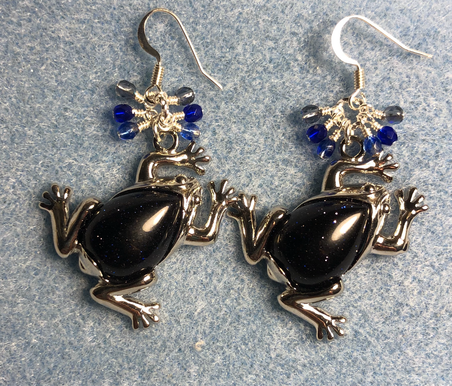 Large silver and blue goldstone gemstone frog charm earrings adorned with small dangling dark blue Czech glass beads.