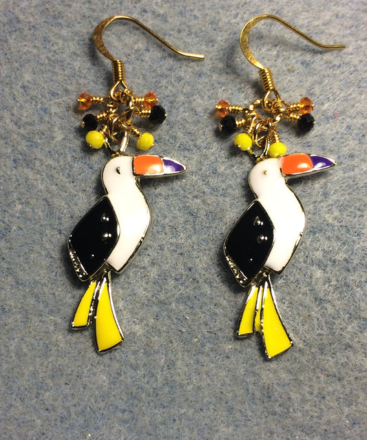 Black, white, yellow, and orange enamel toucan charm earrings adorned with tiny dangling black, yellow, and orange Chinese crystal beads.