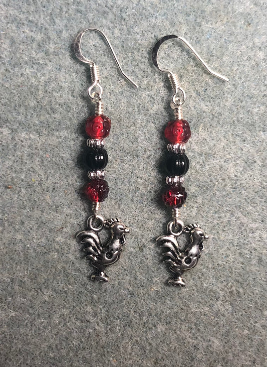 Silver rooster charm earrings adorned with red and black Czech glass beads.