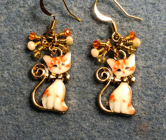 Orange, yellow, and off white enamel cat charm earrings adorned with small dangling orange, yellow, and off white Chinese crystal beads.