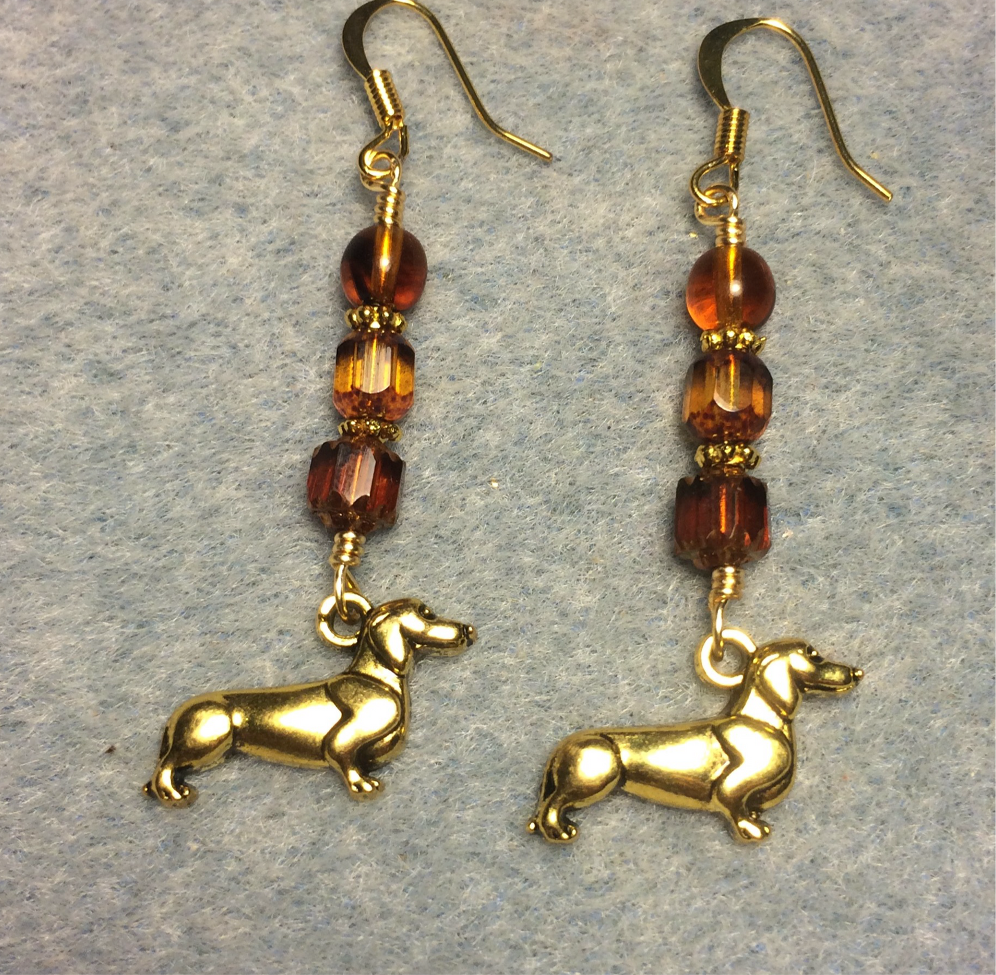 Gold dachshund charm earrings adorned with amber brown Czech glass beads