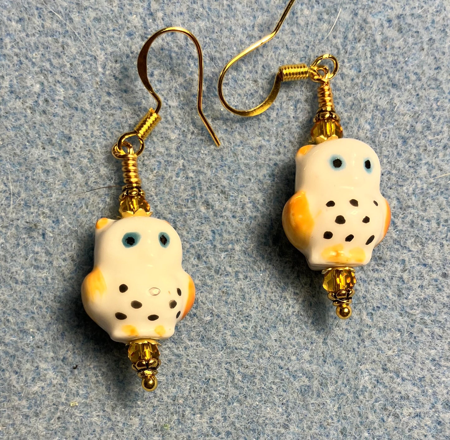 Amber, white, and blue ceramic spotted owl bead earrings adorned with amber Chinese crystal beads.