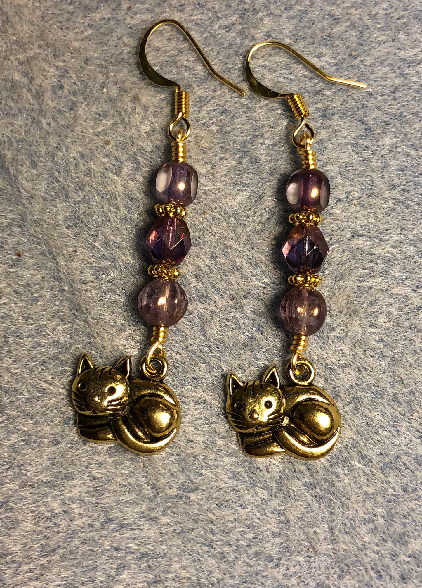 Gold sleeping cat charm earrings adorned with violet Czech glass beads