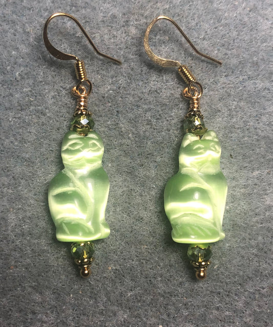 Green fiber optic (cat’s eye) cat bead earrings adorned with light green Chinese crystal beads.