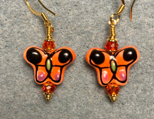 Orange and black ceramic butterfly bead earrings adorned with orange Chinese crystal beads.
