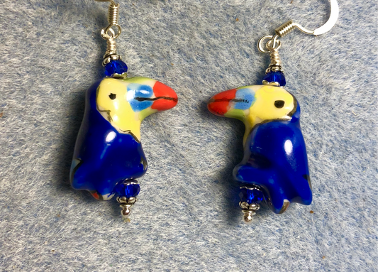 Bright blue, yellow, and red ceramic toucan bead earrings adorned with blue Chinese crystal beads.