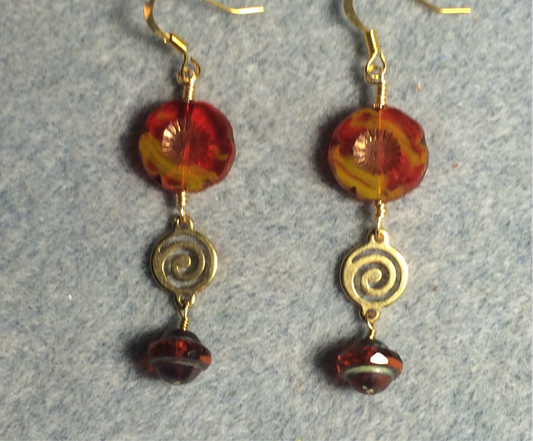 Red and yellow Czech glass pansy bead earrings adorned with gold swirly connectors and translucent reddish Czech glass Saturn beads.