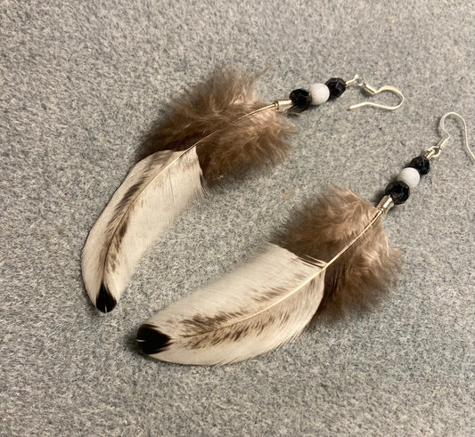 Black and white chicken feather earrings adorned with black Picasso and white Czech glass beads.