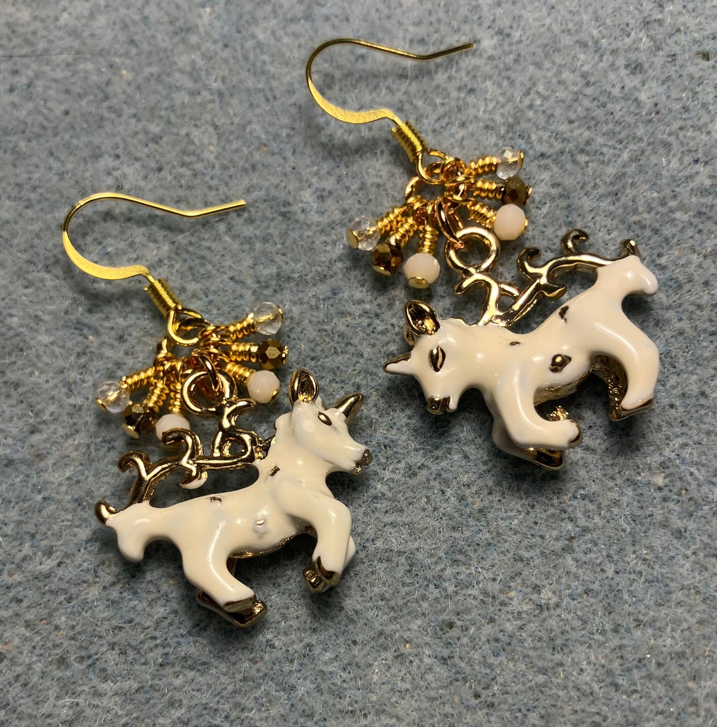 White and gold enamel unicorn charm earrings adorned with tiny dangling white, gold, and clear Chinese crystal beads.