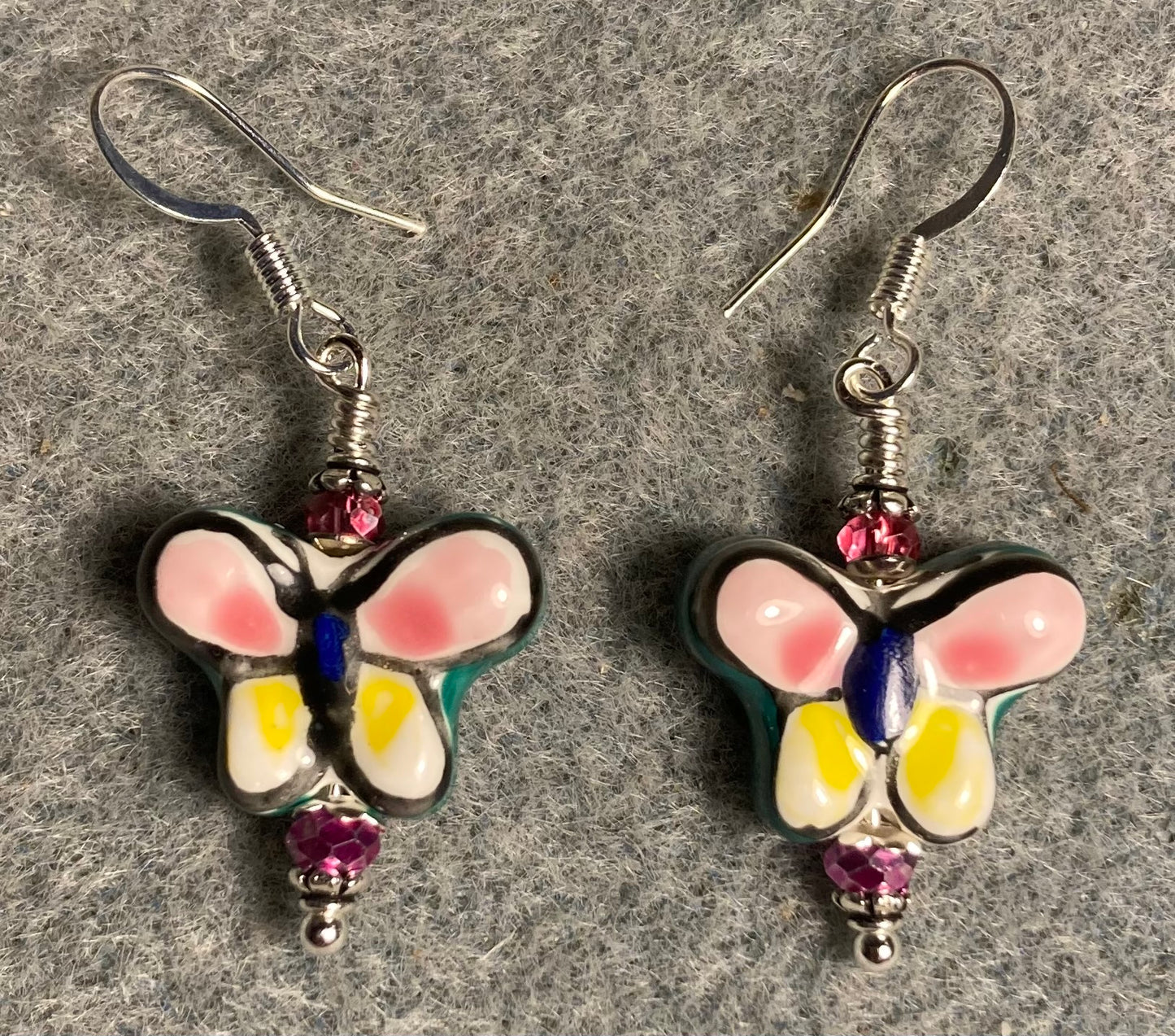 Pink, yellow, and green ceramic butterfly bead earrings adorned with hot pink Chinese crystal beads.