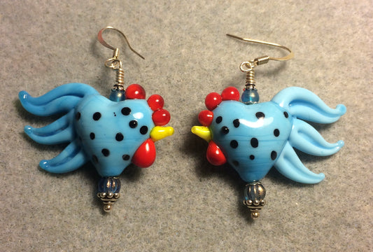 Light blue with black spots heart shaped lamp work rooster bead earrings adorned with light blue Czech glass beads.
