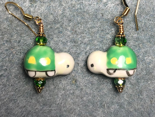 Green, yellow, and white ceramic turtle bead earrings adorned with green Chinese crystal beads.