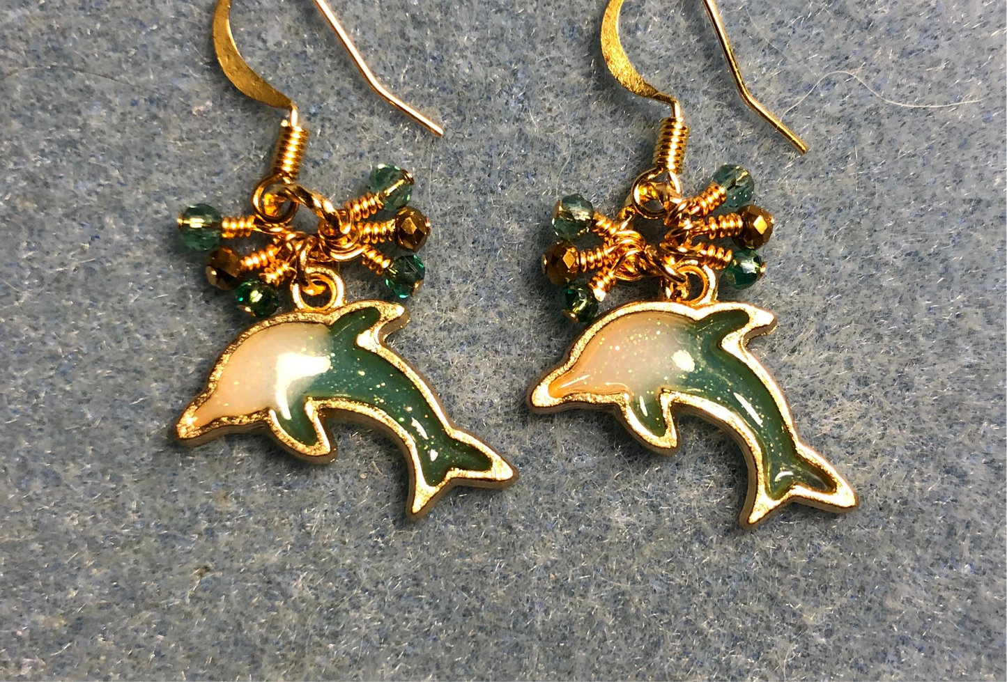 Teal and gold resin dolphin charm earrings adorned with tiny dangling teal and gold Chinese crystal beads.