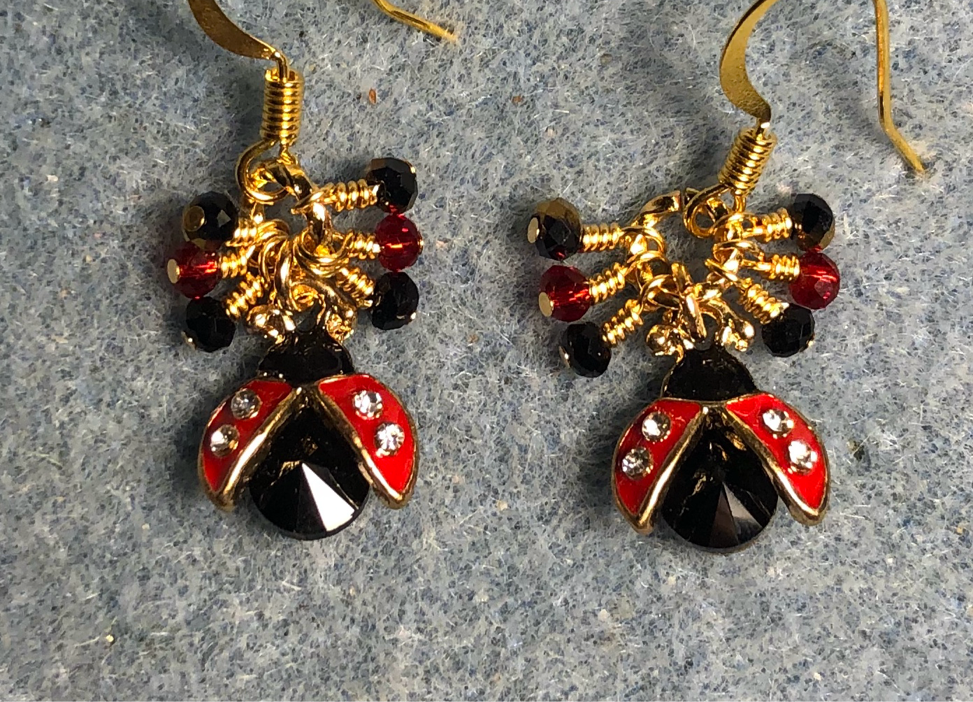 Small black and red enamel and rhinestone ladybug charm earrings adorned with tiny dangling red, black, and gold Chinese crystal beads.