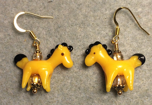 Opaque golden yellow lamp work horse bead earrings adorned with amber Czech glass beads.