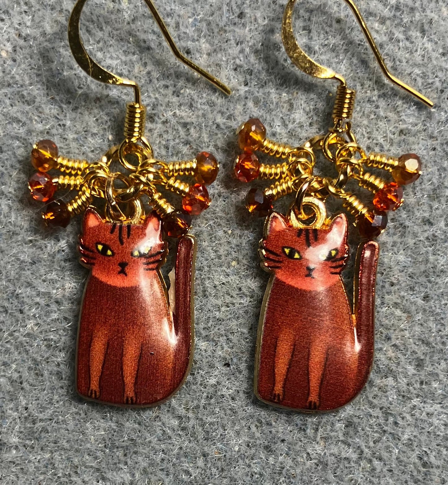 Brown, amber, and orange enamel cat charm earrings adorned with tiny dangling brown, amber, and orange Chinese crystal beads.