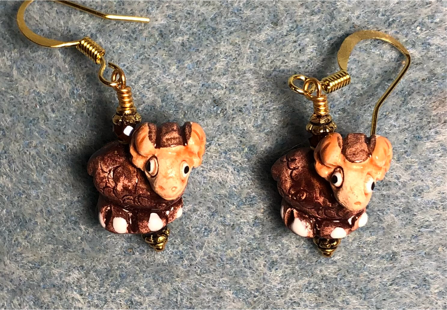 Small brown and tan ceramic ram bead earrings adorned with brown Chinese crystal beads.