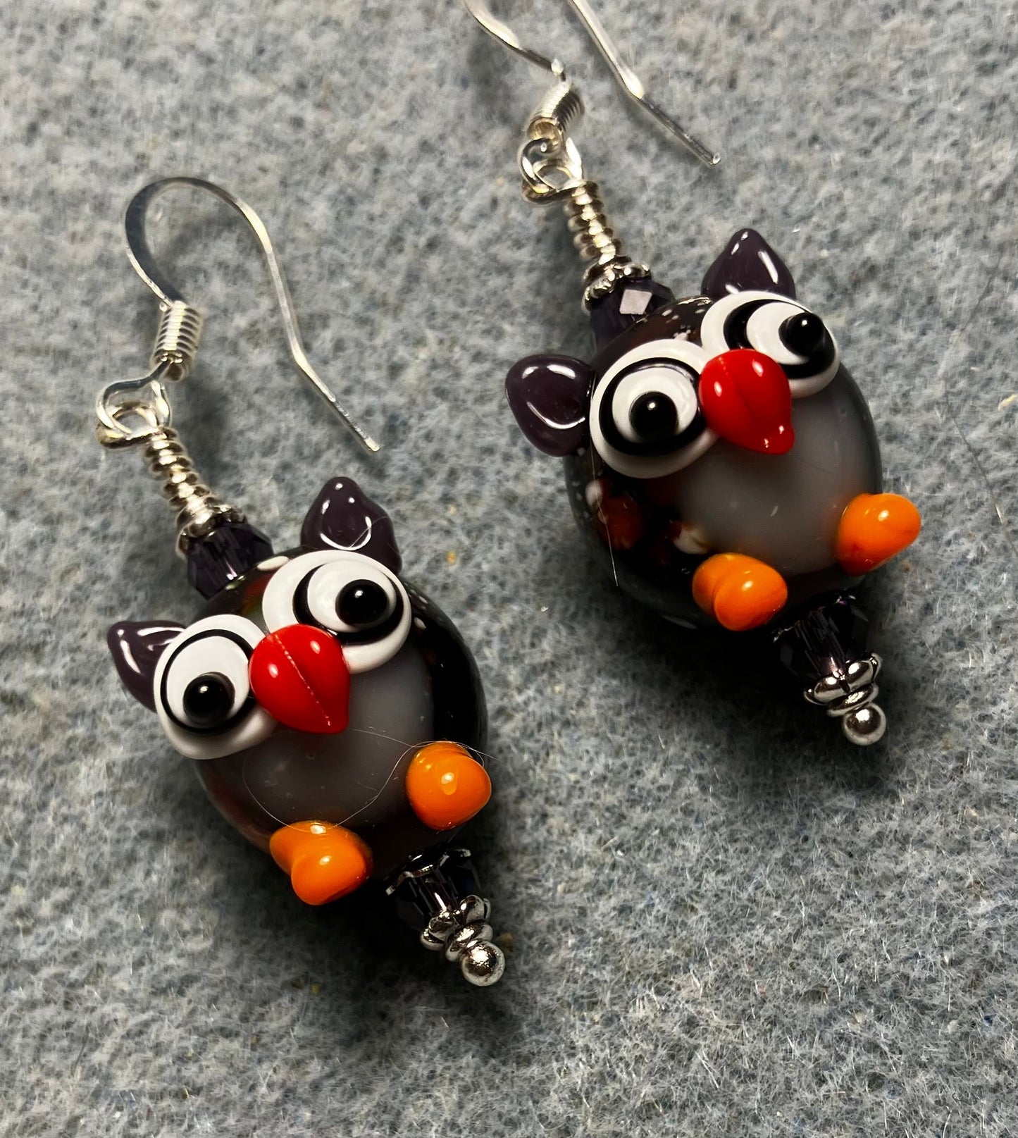 Purple, orange, and red lamp work owl bead earrings adorned with purple Chinese crystal beads.