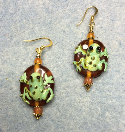 Orange and green lamp work frog bead earrings adorned with orange Czech glass beads.