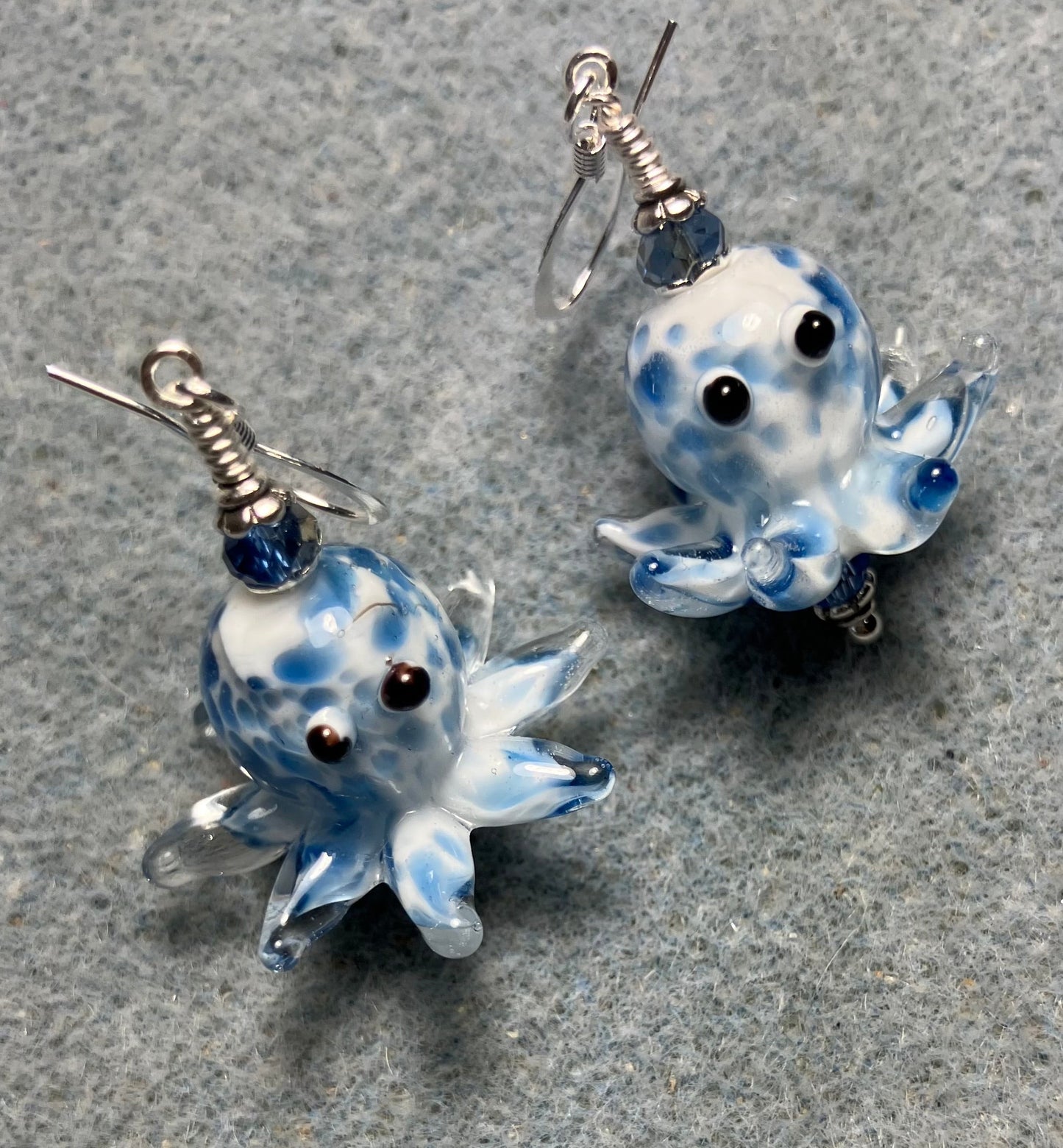 Blue and white mottled lamp work octopus bead earrings adorned with light blue Chinese crystal beads.