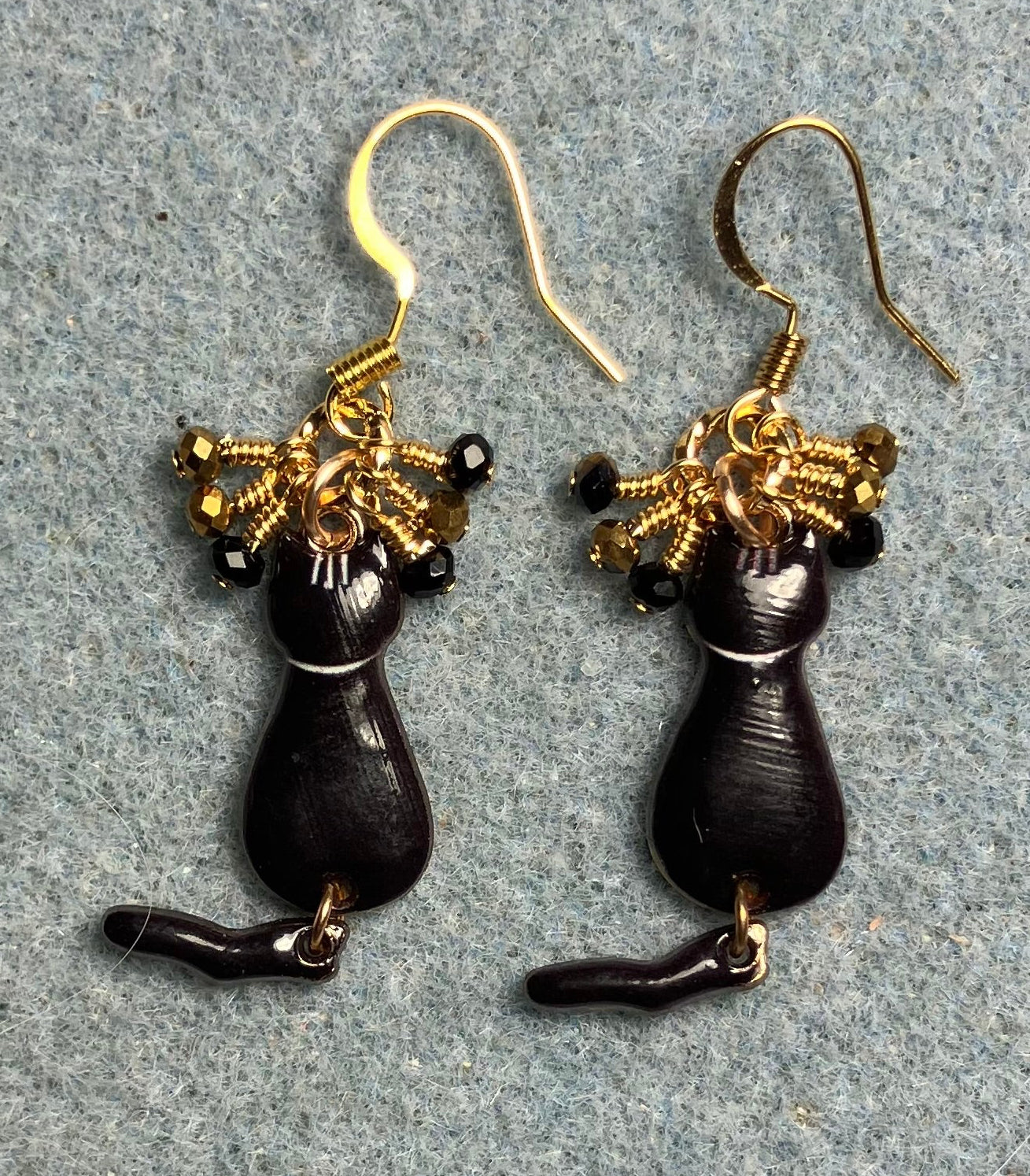 Black and gold enamel cat charm earrings adorned with tiny dangling black and gold Chinese crystal beads.