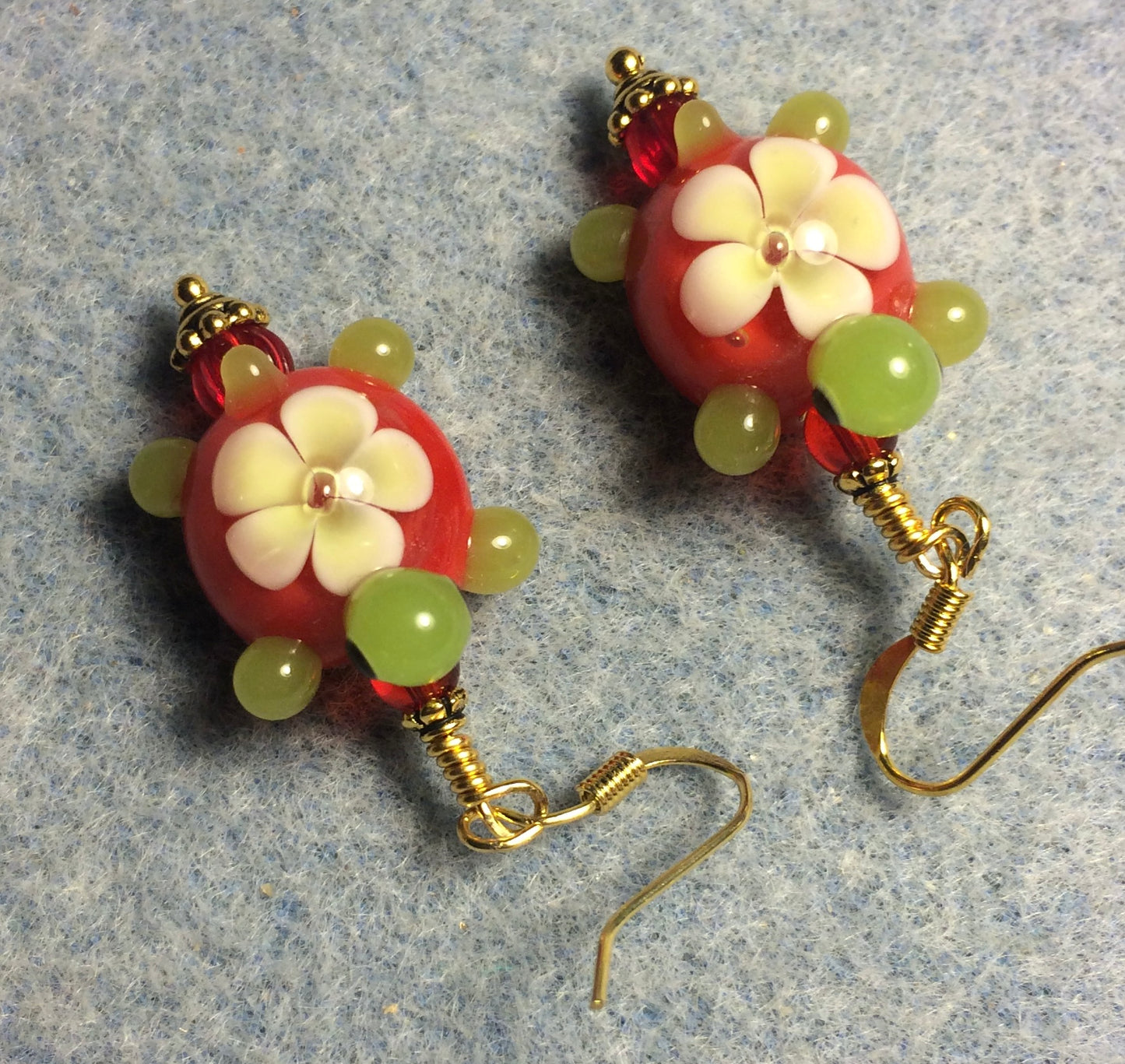 Red and green lamp work turtle bead earrings adorned with red Czech glass beads.