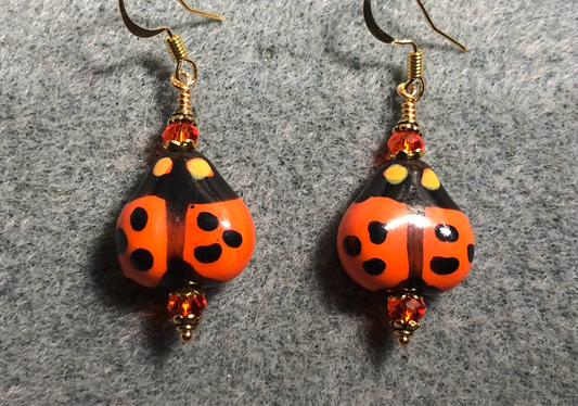 Orange and black ceramic ladybug bead earrings adorned with orange Chinese crystal beads.