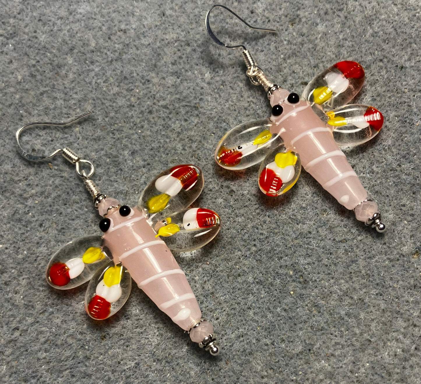 Pink, red, and yellow lamp work dragonfly bead earrings adorned with pink Chinese crystal beads.