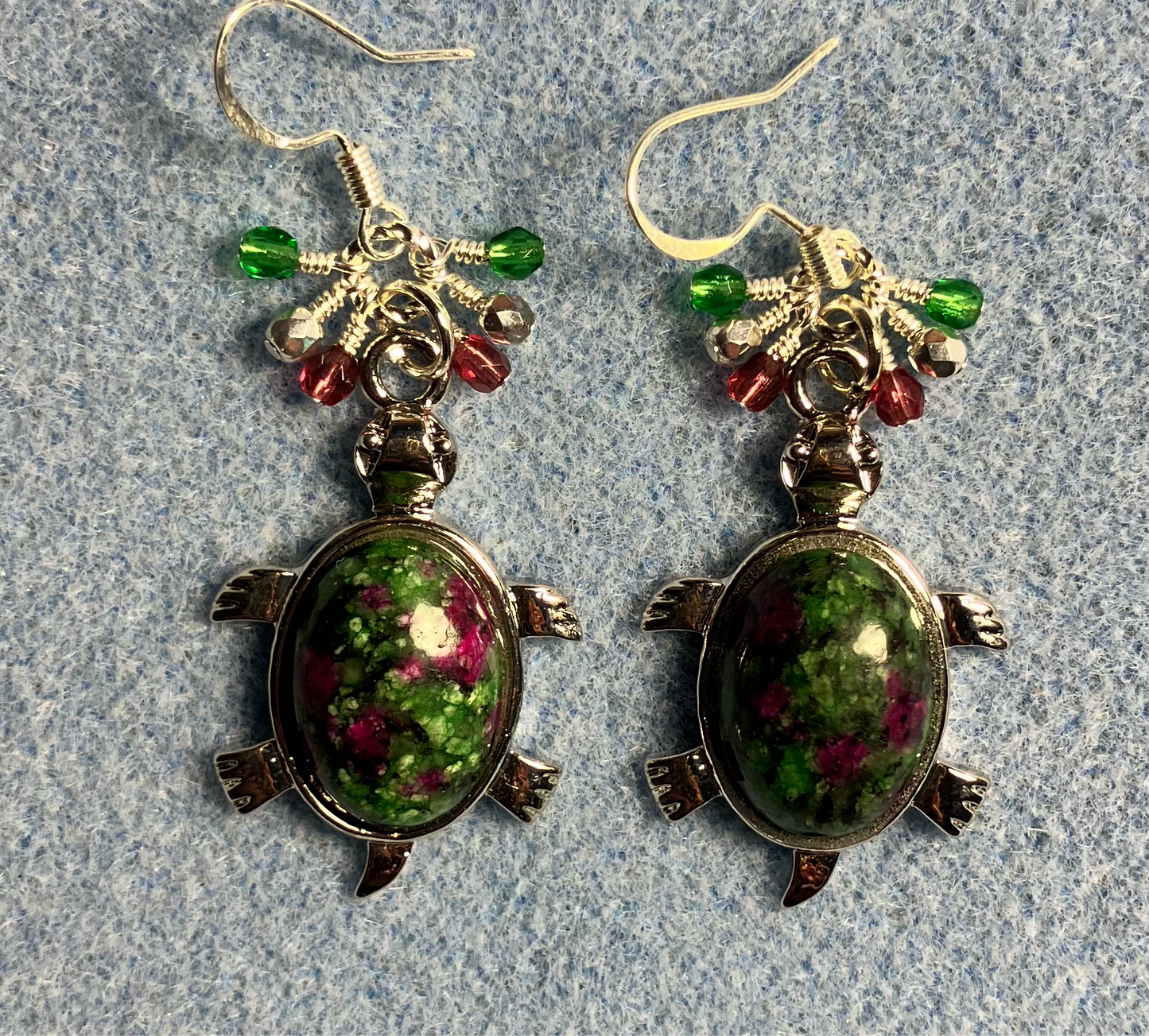 Large silver and red green jasper gemstone turtle charm earrings adorned with small dangling green, silver, and purple Czech glass beads.