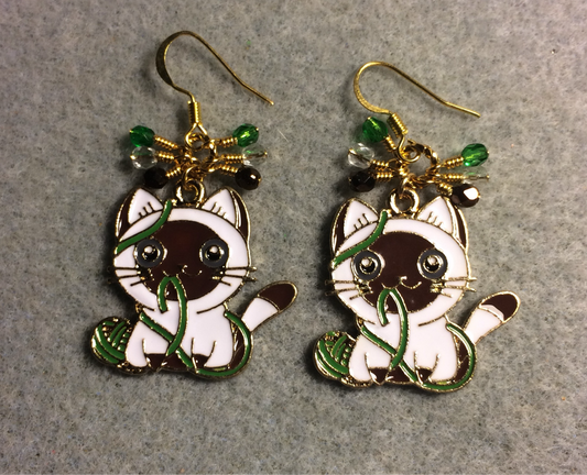 Brown, white, and green enamel cat charm earrings adorned with small dangling brown, white, and green Czech glass beads.