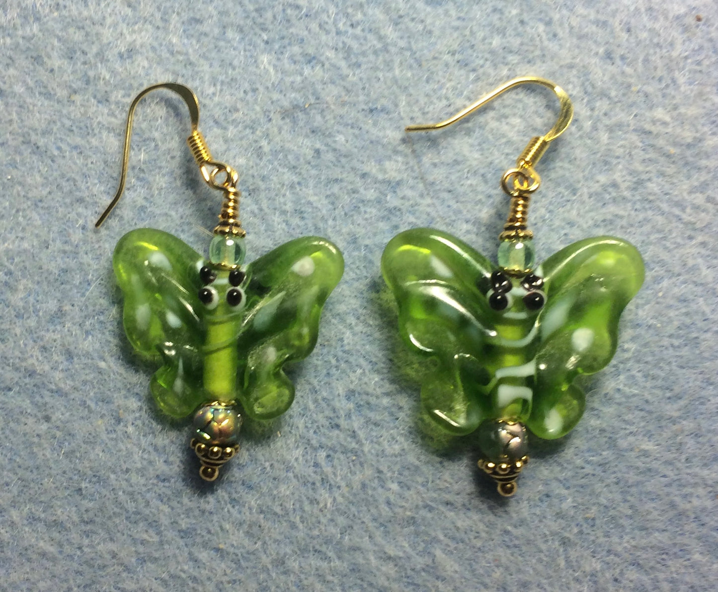 Green lamp work butterfly bead earrings adorned with light green Czech glass beads.