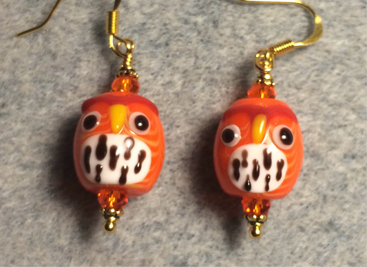 Orange and white lamp work spotted owl bead earrings adorned with orange Chinese crystal beads.