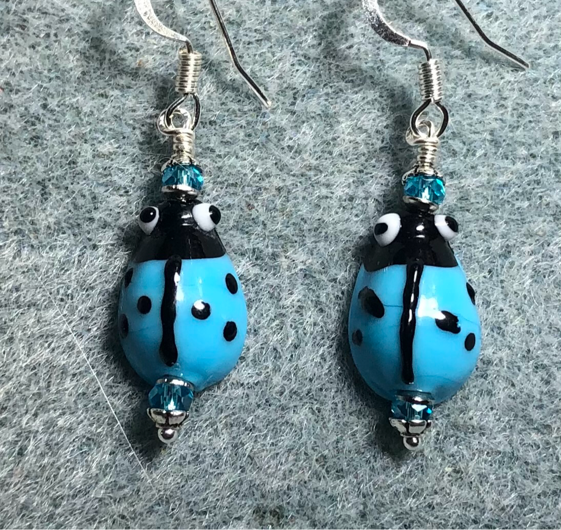 Small turquoise and black lamp work ladybug bead earrings adorned with turquoise Chinese crystal beads.